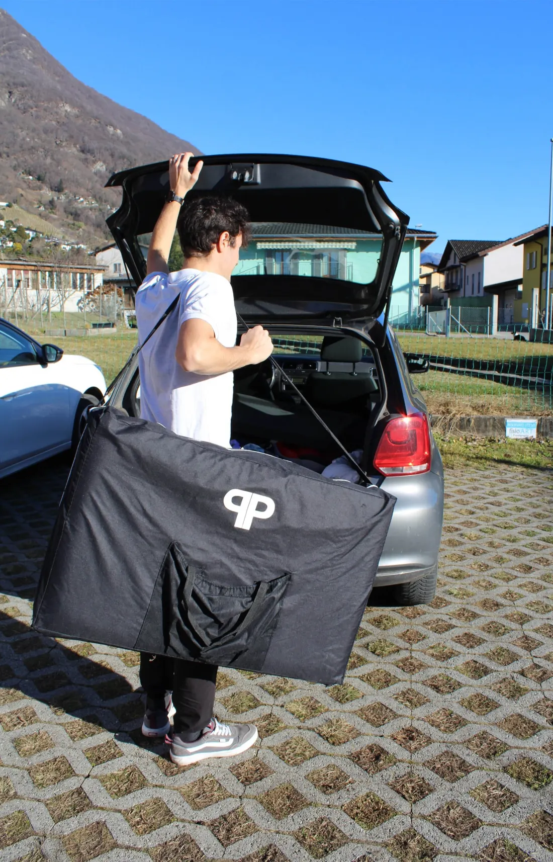 Un fisioterapista di fisioART carica il lettino portatile in auto per una terapia a domicilio